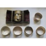 CASE CONTAINING TWO SILVER COLOURED NAPKIN RINGS PLUS OTHER NAPKIN RINGS