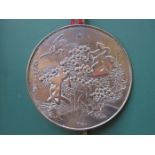 ORIENTAL SILVER COLOURED RELIEF DECORATED CIRCULAR MIRROR