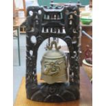 ORIENTAL BRASS RELIEF DECORATED BELL ON PIERCEWORK EBONISED STAND,