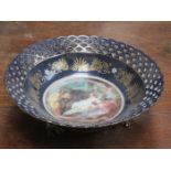 CONTINENTAL STYLE PIERCEWORK DECORATED CERAMIC DISH ON RAISED SUPPORTS WITH CLASSICAL SCENE,