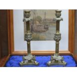PAIR OF BRASS CANDLESTICKS ON RAISED SUPPORTS,