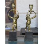 PAIR OF DECORATIVE BRASS FIGURE FORM CANDLE STANDS ON MARBLE EFFECT STAND,