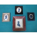 EBONISED FRAMED OVAL RELIEF DECORATED PORTRAIT AND THREE FRAMED SILHOUETTES