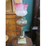 VINTAGE BRASS OIL LAMP WITH AMBER COLOURED GLASS RESERVOIR AND CRANBERRY COLOURED SHADE,