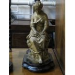 VICTORIAN SEATED GILT METAL FIGURE ON EBONISED TREEN STAND,