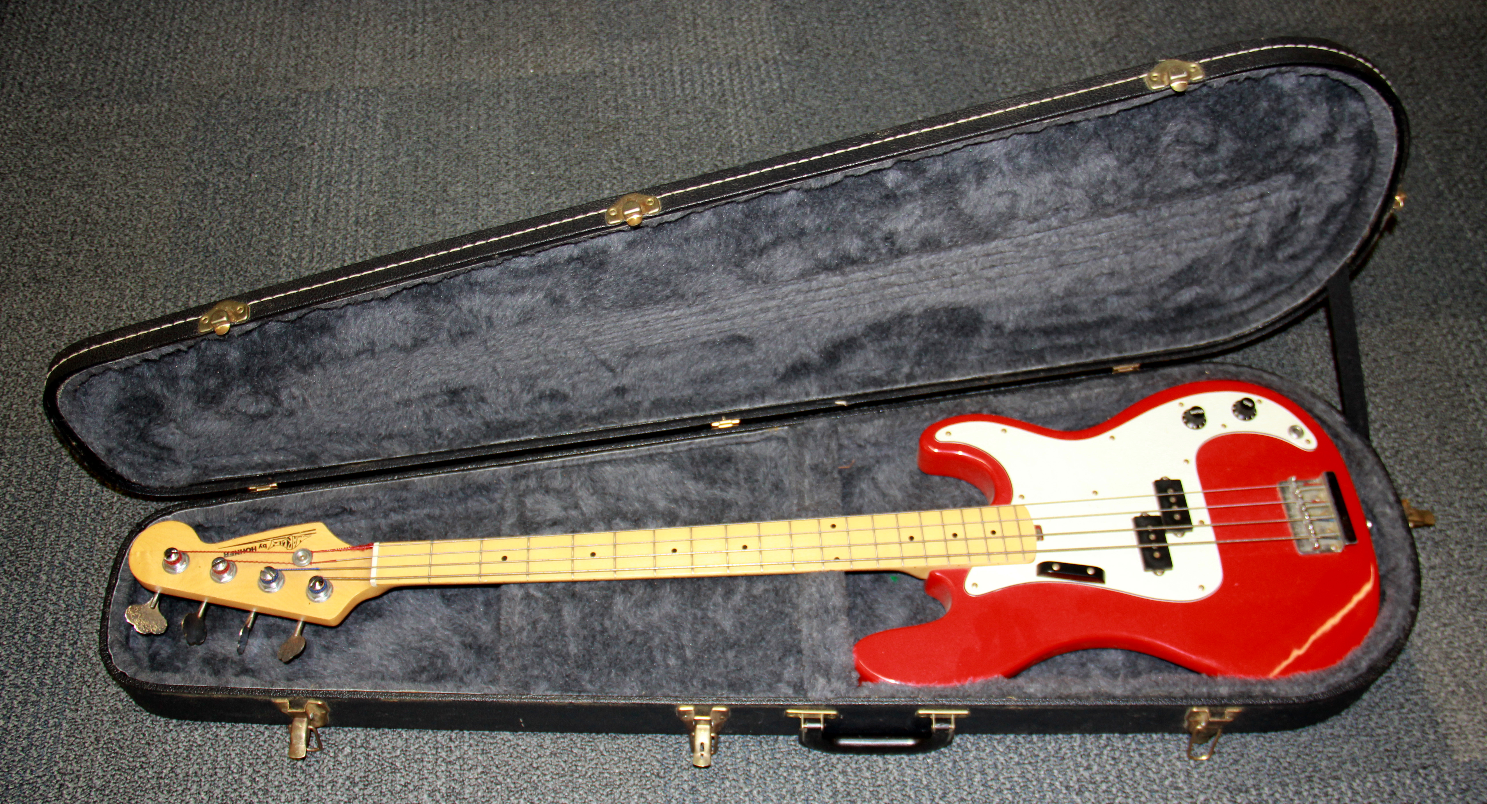 A cased Hohner base guitar.