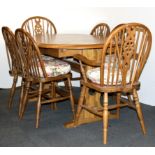 An extending oak dining table and six Windsor style chairs.