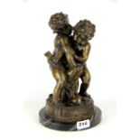 A cast bronze figure of putti on a black and grey marble base, H. 31cm.