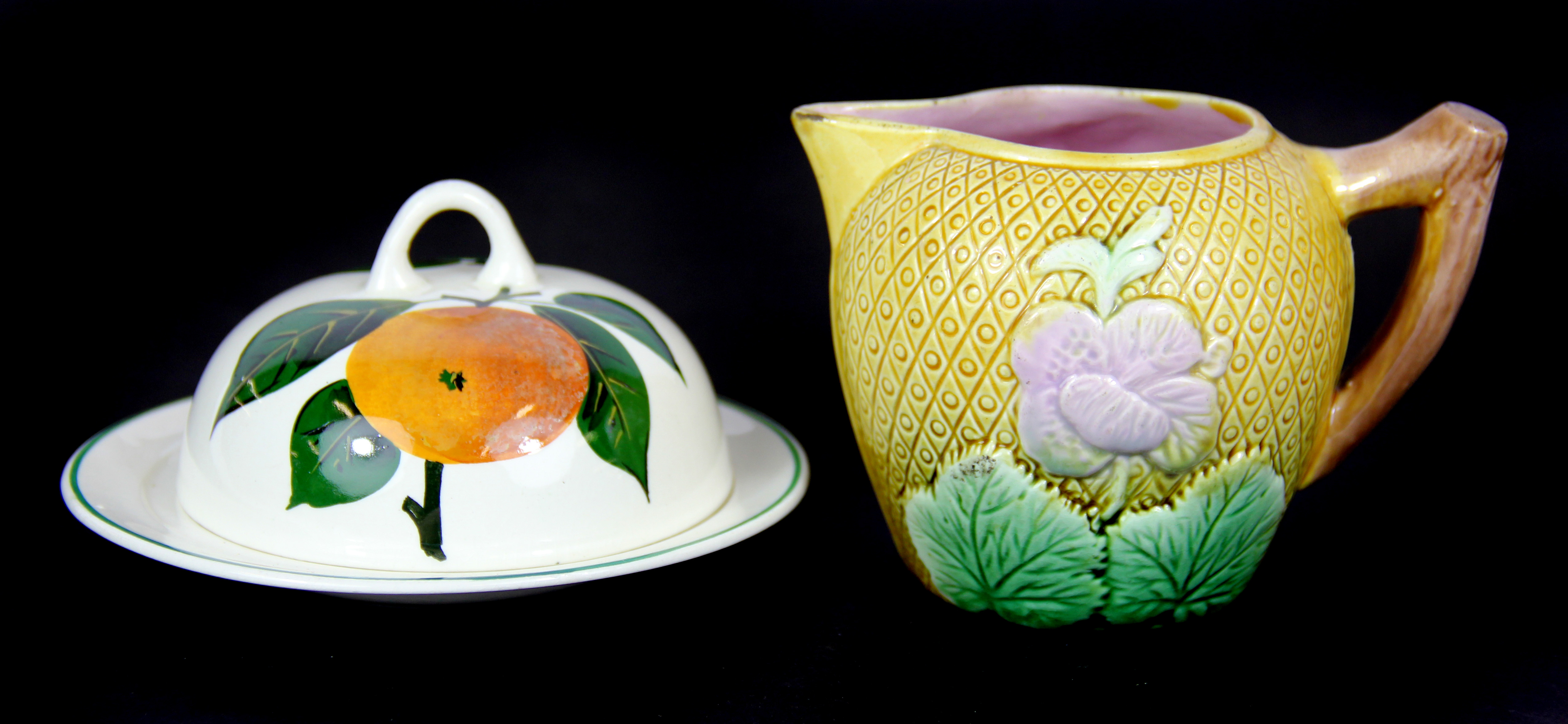 A Plichta (Wemyss) butter dish and cover, Dia. 13cm, together with an English Majolica jug.