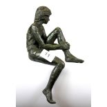 A bronze finished maquette of a girl in sitting position on the edge of a shelf, H. 28cm.