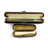 A 1920's cased enamelled and gilt Alpaca cigarette holder together with a further cigarette holder.
