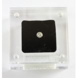 An unmounted 0.56ct brilliant cut diamond in a display case.