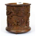 A Chinese carved bamboo brush pot decorated with scenes of scholars in a garden among banyan