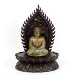 A cast bronze figure of a seated Buddha, H. 10cm seated on a carved hardwood base with flame