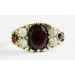 A 9ct yellow gold garnet and white stone set ring, (M.5).