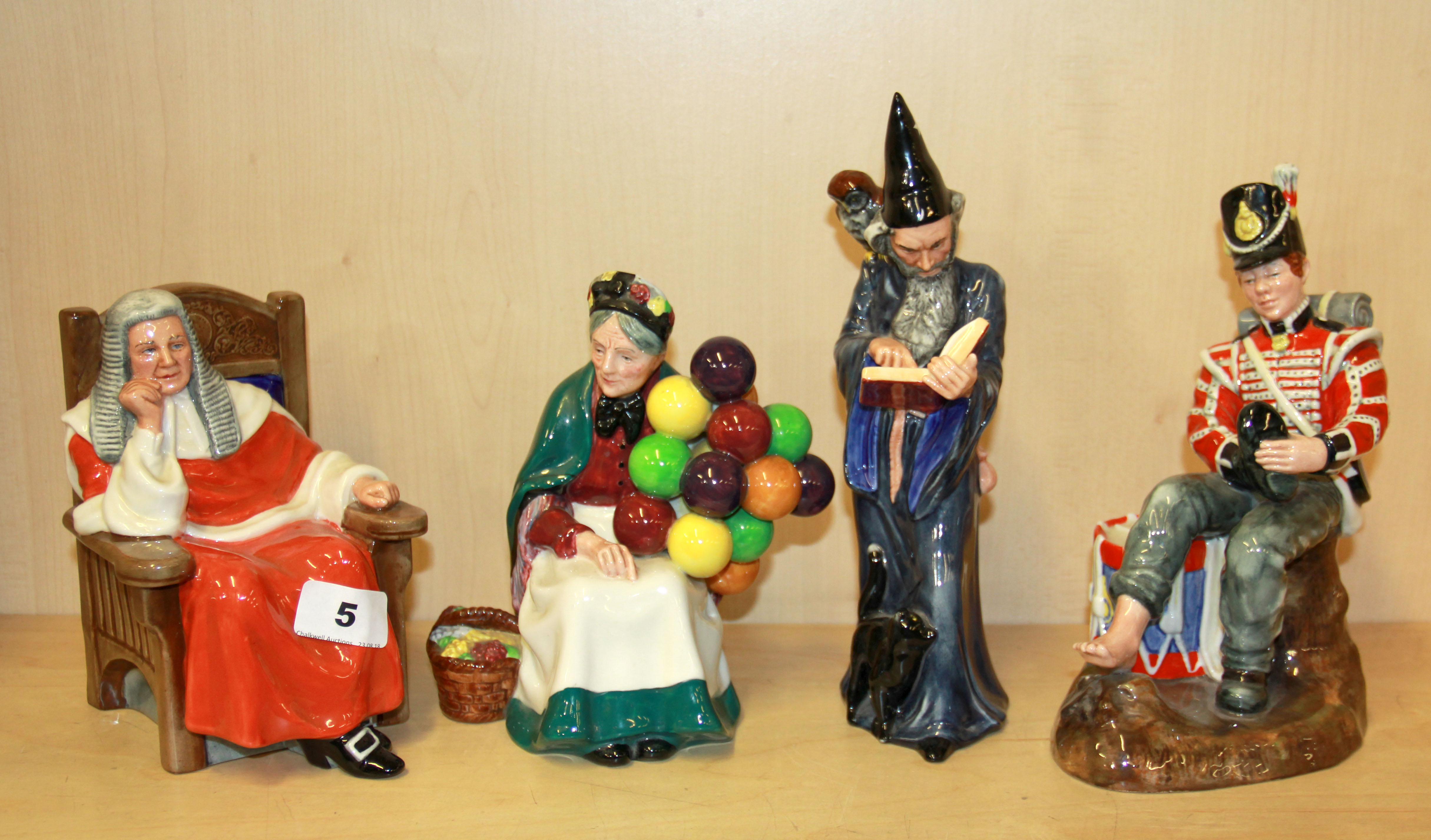 Four Royal Doulton figures, 'Judge' 'The Old Balloon seller - H.N.1315' 'The Wizard' and Drummer