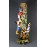 A large early 20th Century hand made pottery vase of children climbing a tree, H. 60cm.