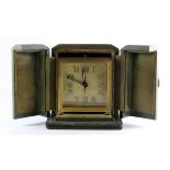 A cased 1930's gilt travel alarm clock, H. 9cm.