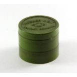 A small green Bakelite box containing a vintage pair of Mueller welt contact lenses.