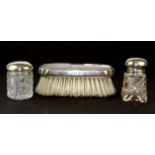 A hallmarked silver backed brush and two dressing table items.