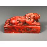 A mid-20th Century Chinese carved red soapstone seal, H. 4cm, L. 7.5cm.