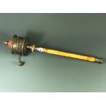 A Tibetan hammered copper and white metal prayer wheel, H. 60cm.