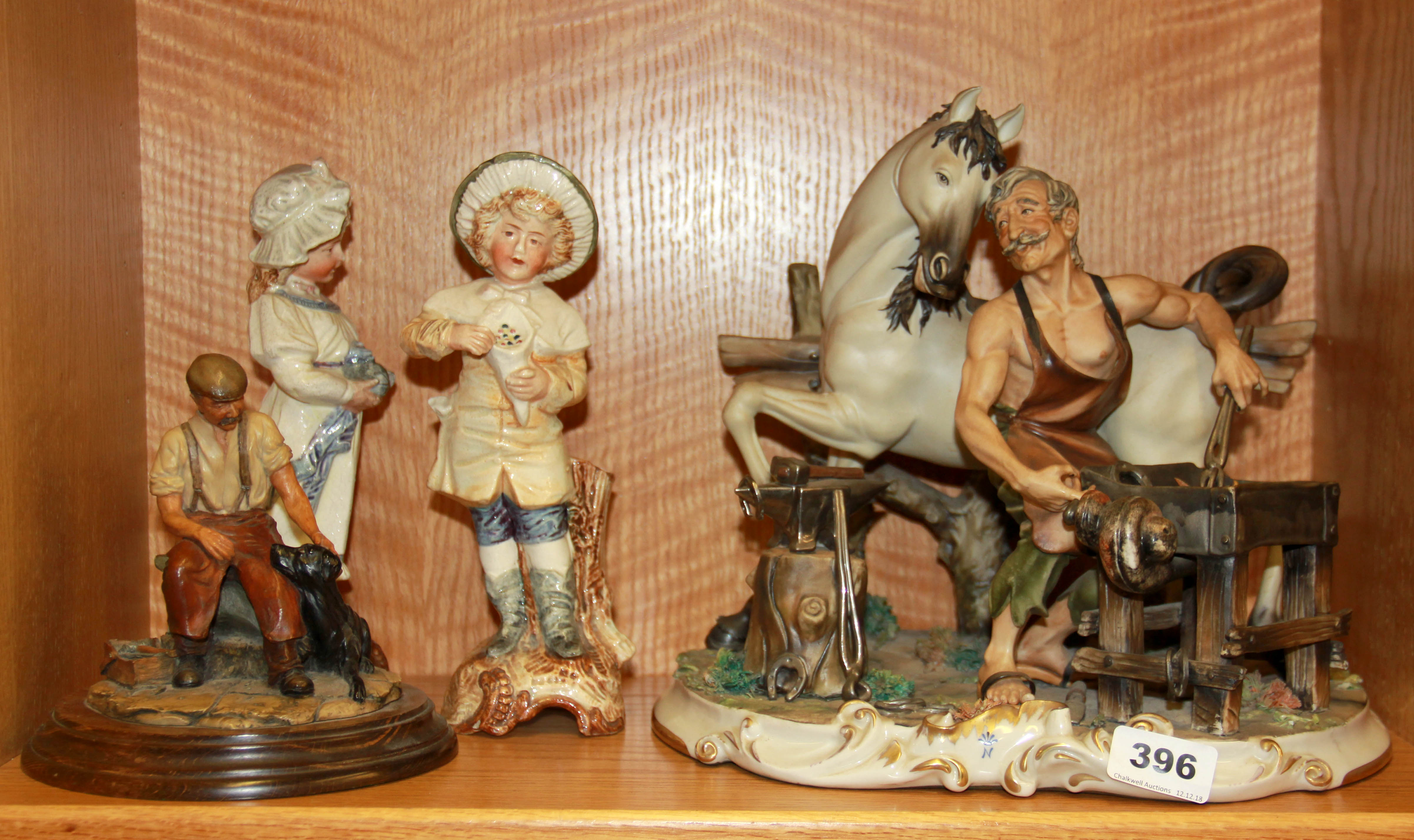 A large Capodimonte figure of a blacksmith and three other figures, H. 28cm.