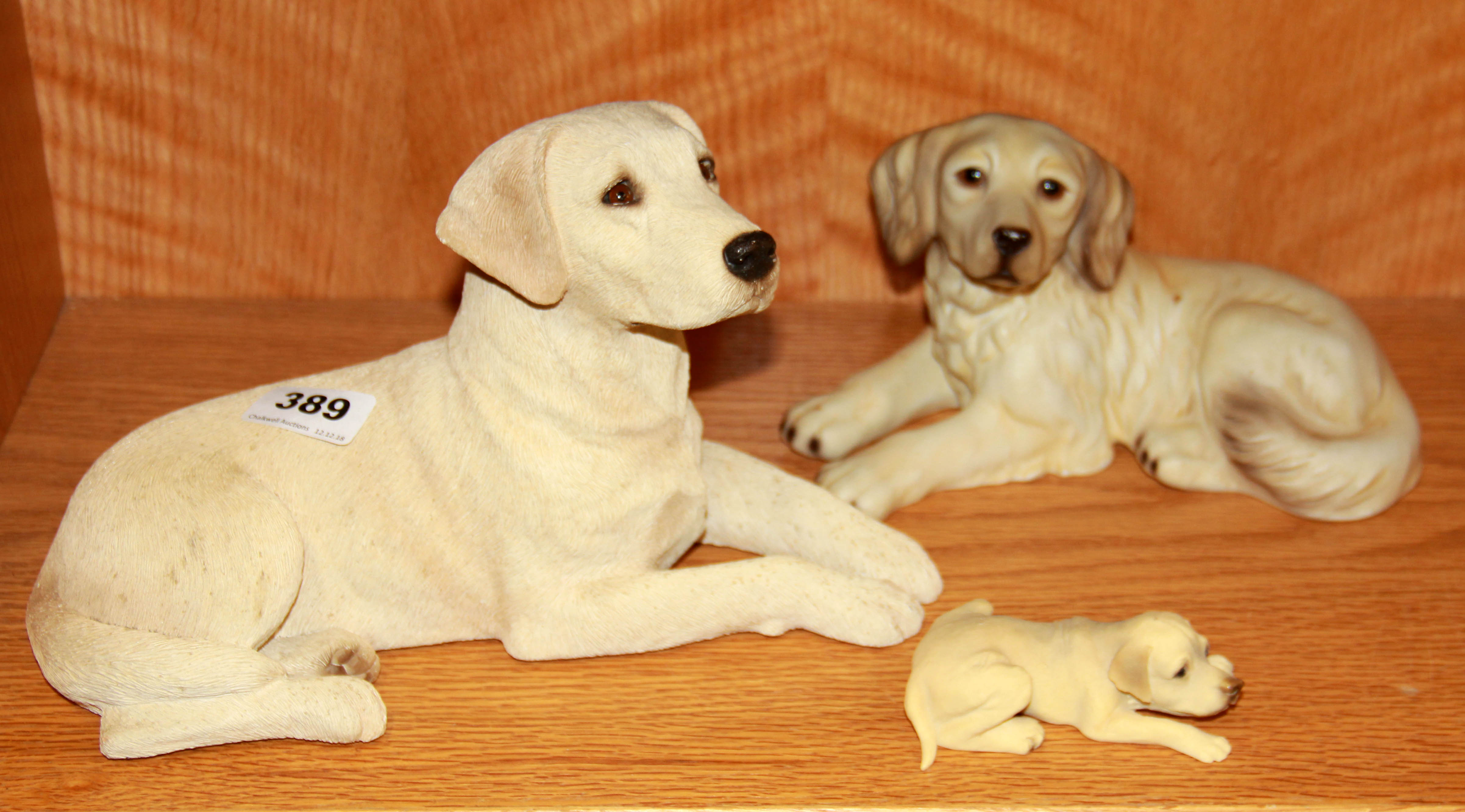 A signed sandcast figure of a golden Labrador together with a figure of a golden retriever and a