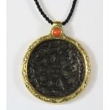 A Tibetan gilt mounted bronze pendant, Dia. 4.5cm.