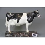 A ceramic presentation figure of a cow on a marble base, signed D'Aquino, H. 418cm, L. 24cm.