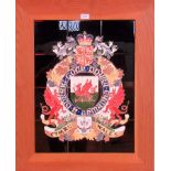 A composite pottery tile panel with a tube lined and enamelled coat of arms for Wales, 61cm x 46cm.