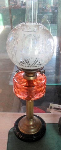 A Victorian pedestal oil lamp with ribbed pink glass reservoir and a duplex burner system with acid