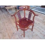 A Chinese rosewood corner chair with shaped top rail and pierced splats.