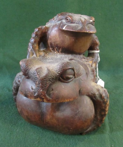 A Japanese Meiji period carved hardwood Okimono depicting a large pot bellied toad being clambered