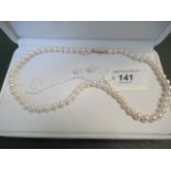 A uniform sized cultured pearl necklace with a pair of cultured pearl earrings en suite.