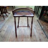 A mahogany effect Edwardian desk stool with saddle seat and galleried back,