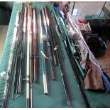 A collection of fishing tackle, rods, spinning rods, perch poles, landing nets and other items.