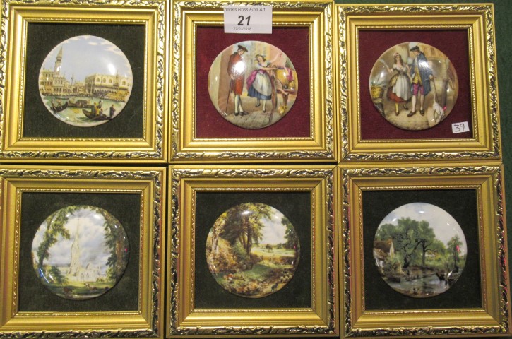 A collection of six gilt framed miniature porcelain pot lids, decorated with artistic scenes,