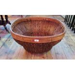 A large and impressive wicker work basket of square tapering outline.