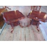 A pair of George IV-style cartouche topped mahogany side tables on splayed and castor supports.