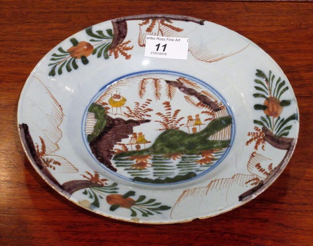 An 18th century Bristol Delft dessert plate, decorated in manganese, copper green and other colours.