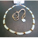 A gold mounted pale jade necklace, comprising carved jade panels with chain link and gold clasp,
