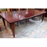 An Edwardian mahogany and herringbone strung extending dining table,