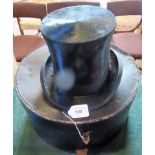 A silk top hat with felt band in an associated hat box.