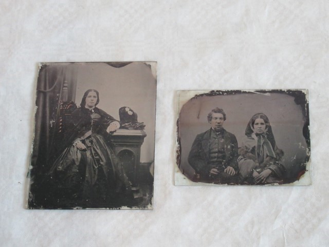 Two Edwardian photographic negatives, each of figures in an interior.