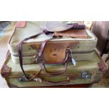 Two early 20th century canvas and leather bound suitcases, a pair of cork covered table tennis bats,
