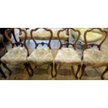 A set of four Victorian walnut dining chairs, each having serpentine rail, florally carved splat,