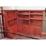 An Edwardian oak corner bookcase, having six adjustable shelves over three pairs of cupboard doors.