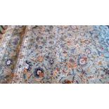A large Indian wool carpet, woven with a busy foliate ground,