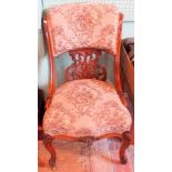 A Victorian walnut salon chair, having a rolled back, pierced florally carved splat,